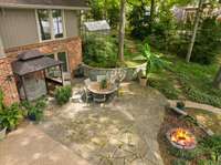 This flagstone portion of the patio has a covered grilling area, built-in firepit and steps up to the side yard & greenhouse. This side area would also be a good spot for a pool if you wanted to keep all of the patio space below.