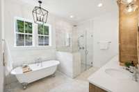 Beautifully designed primary bathroom in white marble.