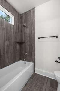 Bathroom includes custom tiling and a window feature for amazing natural light.