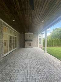 Expansive Covered Living area with a fireplace that overlooks private back yard. photo taken 7/14/24