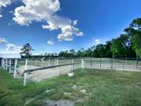 4 acres of fenced in pasture land with a creek at the back behind the fencing.