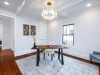 Office area off of front entryway is sure to be a focal area with the boasted coffered ceiling and oyster shell inspired lighting.  Let's call attention to the rich refurbished original hardwood floors.