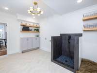 Several great features adorn this mud room/laundry room.  We must note the chevron tile, dog shower, pet station and folding station!  Let's not forget the retro light fixture that ties it all together!