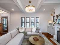 Charming living room with coffered ceiling and cabinet built-ins that frame the fireplace.