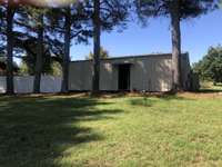 Large Metal Garage with Workshop.  2 Rooms.  One was originally used as a painting area.  Electric and 1/2 Bath.