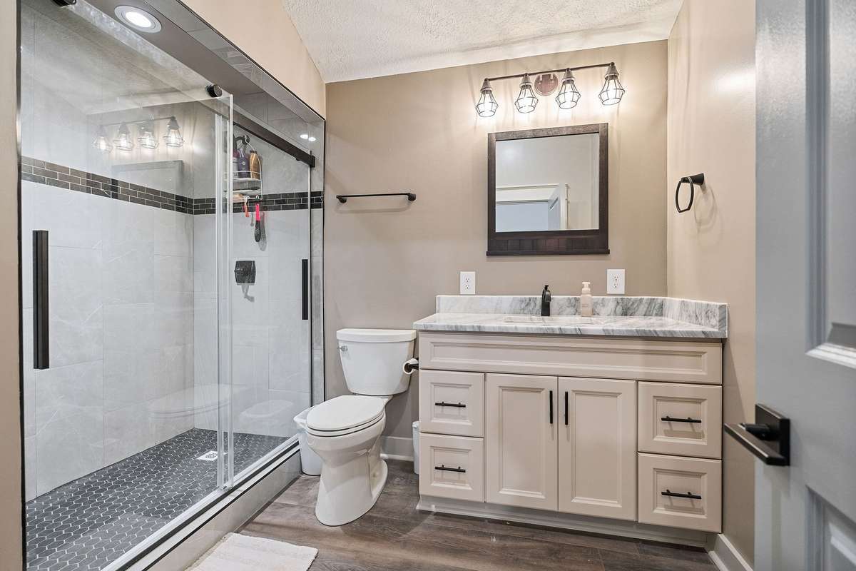 Guest home has full bath with over sized walk-in tile shower and glass doors.