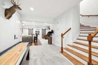 The curved secondary staircase leads to the lower level entertainment area.