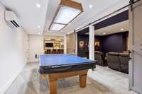 The game room is adjacent to the media room and open to the bar area.