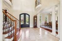 Step into a stunning grand foyer that makes an unforgettable first impression, featuring elegant double iron doors and marble floors.