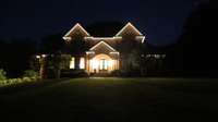 Evening lights adorn the home. This complex lighting system offers color options for every season.
