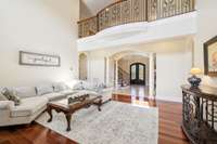 The two story living room creates a sense of openness. Above the catwalk offers  and eye-catching architectural feature, framed with exquisite ironwork on the railing.