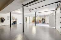 The garage is beyond three car offering additional space for storage. This space gives access to the motor room for the elevator as well as a separate room for storage or workroom.