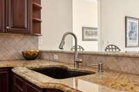 The undermount kitchen sink blends seamlessly with the granite counter tops.