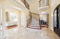 This captivating staircase will greet your guests as they enter the home. Above, a charming Juliette balcony overlooks the foyer.