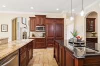 This view of the kitchen features a coffee bar and the refrigerator which is designed to seamlessly blend with the cabinets.