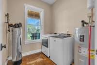 A functional walk-in laundry room equipped with a whole-house water filtration system, ensuring clean, filtered water throughout the home. Beautiful views even while doing the laundry!