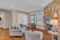 Hearth sitting area anchored by a stunning floor-to-ceiling stone woodburning fireplace. The natural stone adds rustic elegance which creates the perfect spot for relaxation and enjoying the glow of a crackling fire.