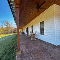 Spacios rocking chair front porch perfect for enjoying stunning views of the surrounding countryside. The tranquil setting offers a private retreat, blending classic design with natural beauty for the ultimate in relaxation and comfort.