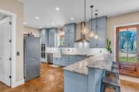A large farmhouse, fireclay sink anchors the space and overlooks the stunning farm views. Natural light floods the space, creating a seamless connection between indoor and outdoor living.