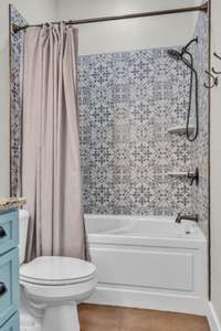 Gorgeous patterned tile surround the tub/shower and complements the blue cabinetry wonderfully.
