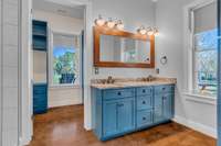 A spacious owner's bath with a double vanity featuring sleek granite countertops.