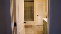 Primary bathroom with combo tub/shower and double vanity