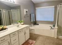 The primary bath has sufficient space with separate vanities, tub and a stand- alone shower.
