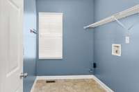 Laundry room located on the first floor, beside the kitchen and garage.