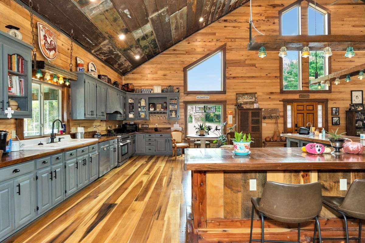 Kitchen- poplar flooring, hickory walls, large windows, walnut countertop and trim, vaulted metal roof, large windows, matching stainless appliances, large side by side refrigerator