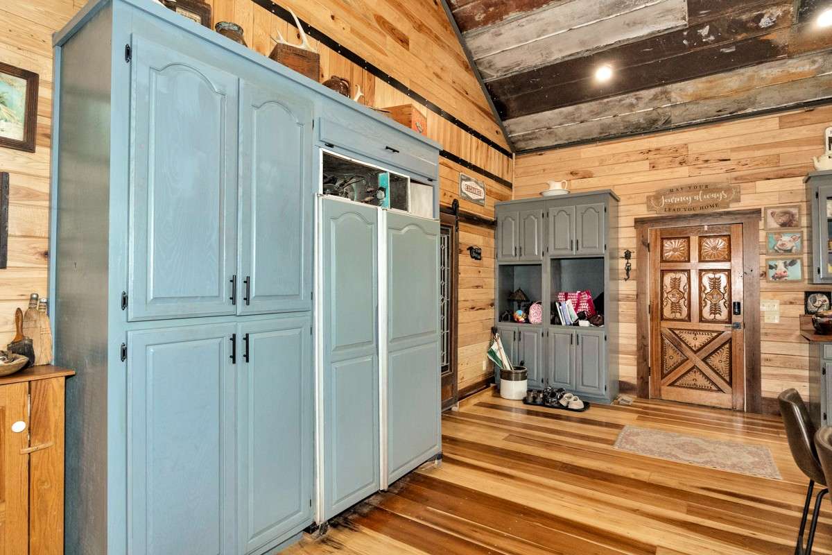 Kitchen- poplar flooring, hickory walls, large windows, walnut countertop and trim, vaulted metal roof, large windows, matching stainless appliances, large side by side refrigerator