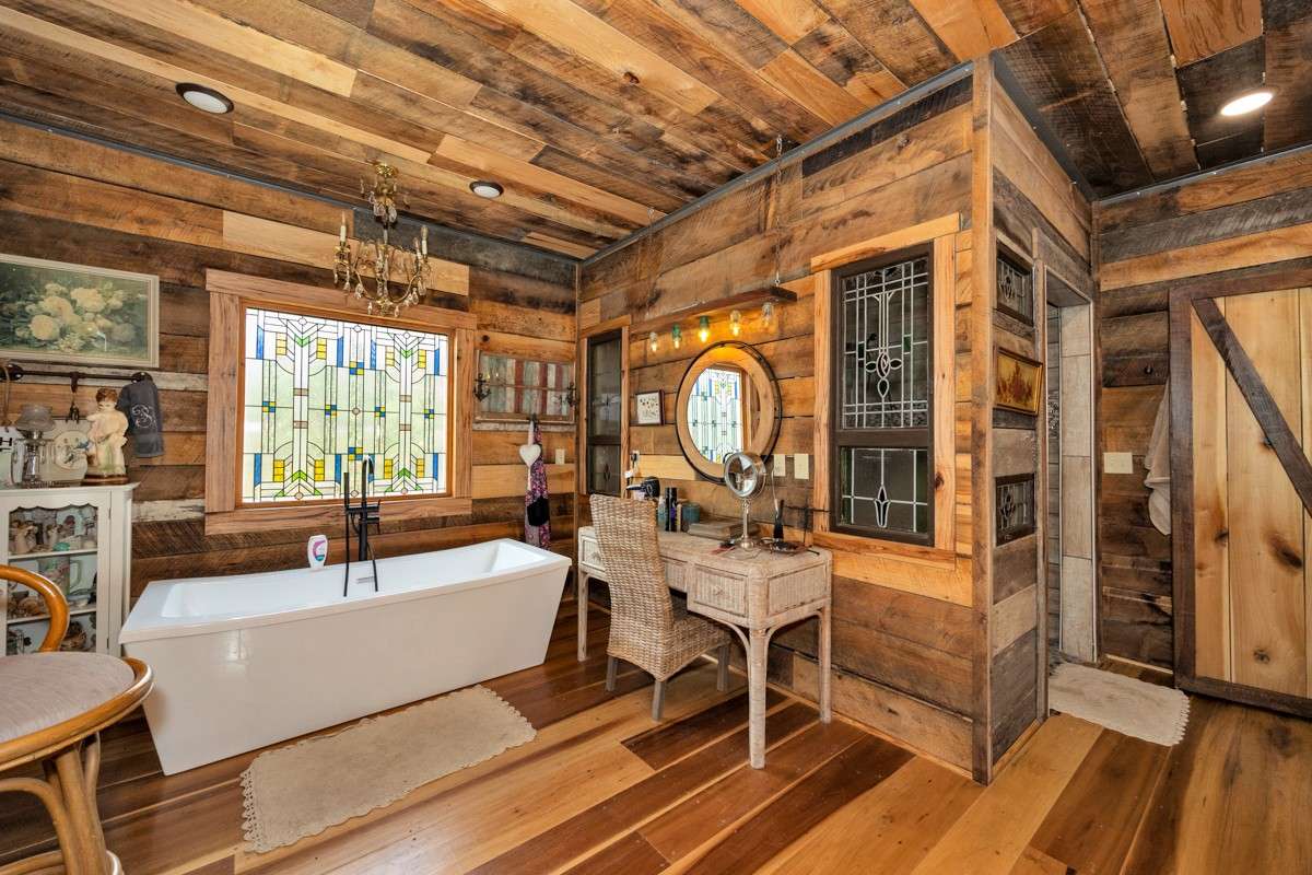 Master Bath- main level- poplar flooring, hickory walls, double vanities, soaking tub, custom window, custom tile shower with two shower heads, recessed lighting