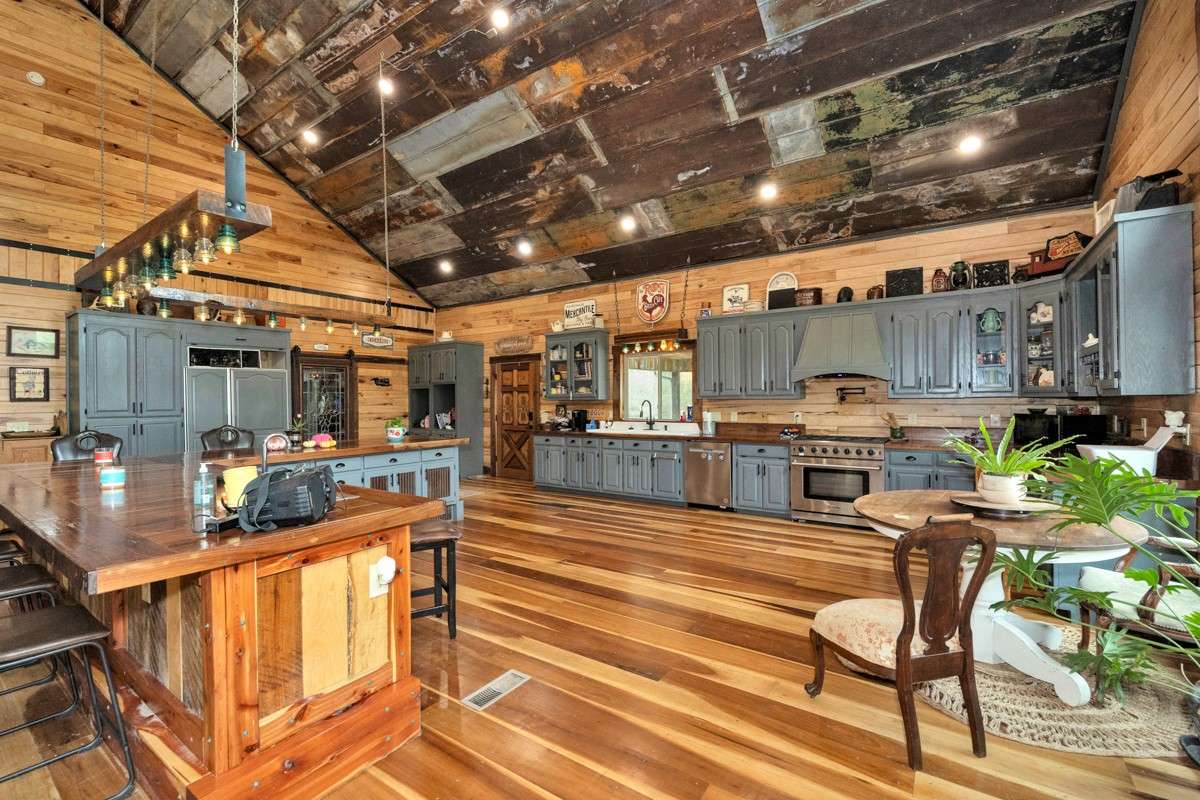 Kitchen- poplar flooring, hickory walls, large windows, walnut countertop and trim, vaulted metal roof, large windows, matching stainless appliances, large side by side refrigerator