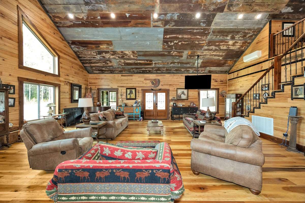 Living Room- main floor- poplar flooring, hickory walls, vaulted metal ceiling, recessed lighting, large windows