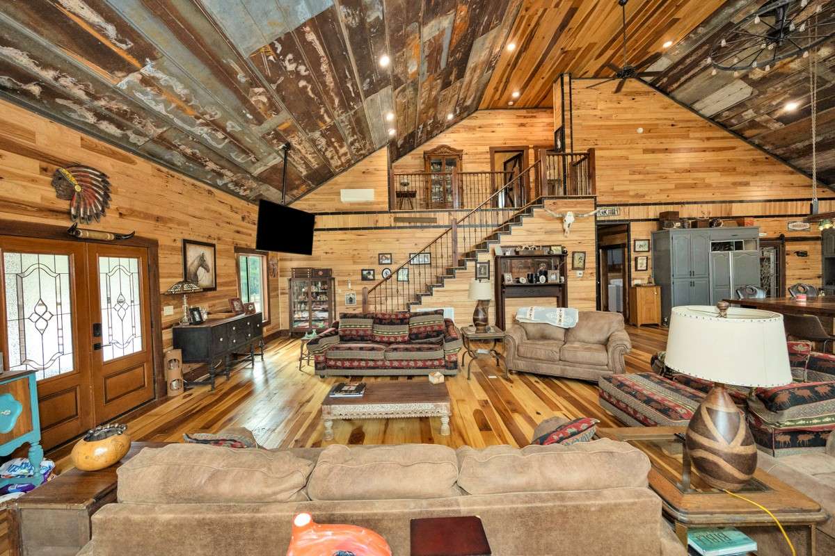 Living Room- main floor- poplar flooring, hickory walls, vaulted metal ceiling, recessed lighting, large windows