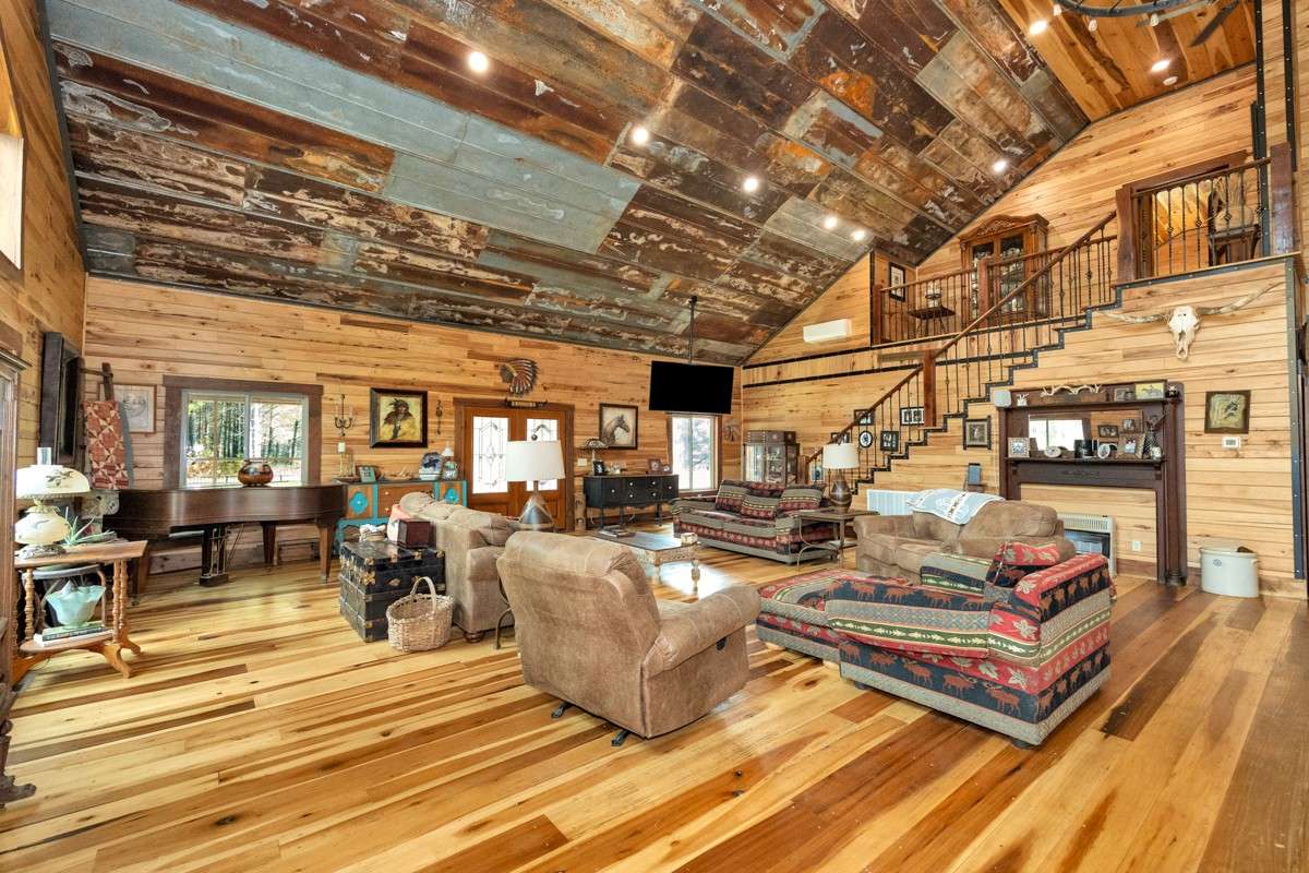 Living Room- main floor- poplar flooring, hickory walls, vaulted metal ceiling, recessed lighting, large windows