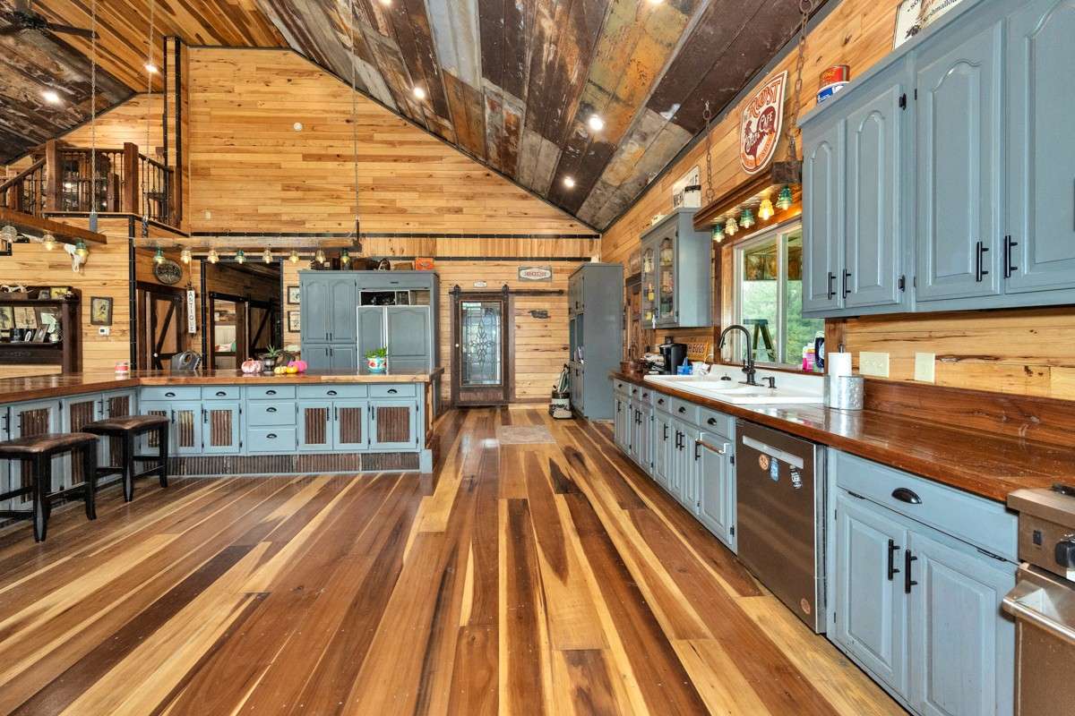 Kitchen- poplar flooring, hickory walls, large windows, walnut countertop and trim, vaulted metal roof, large windows, matching stainless appliances, large side by side refrigerator
