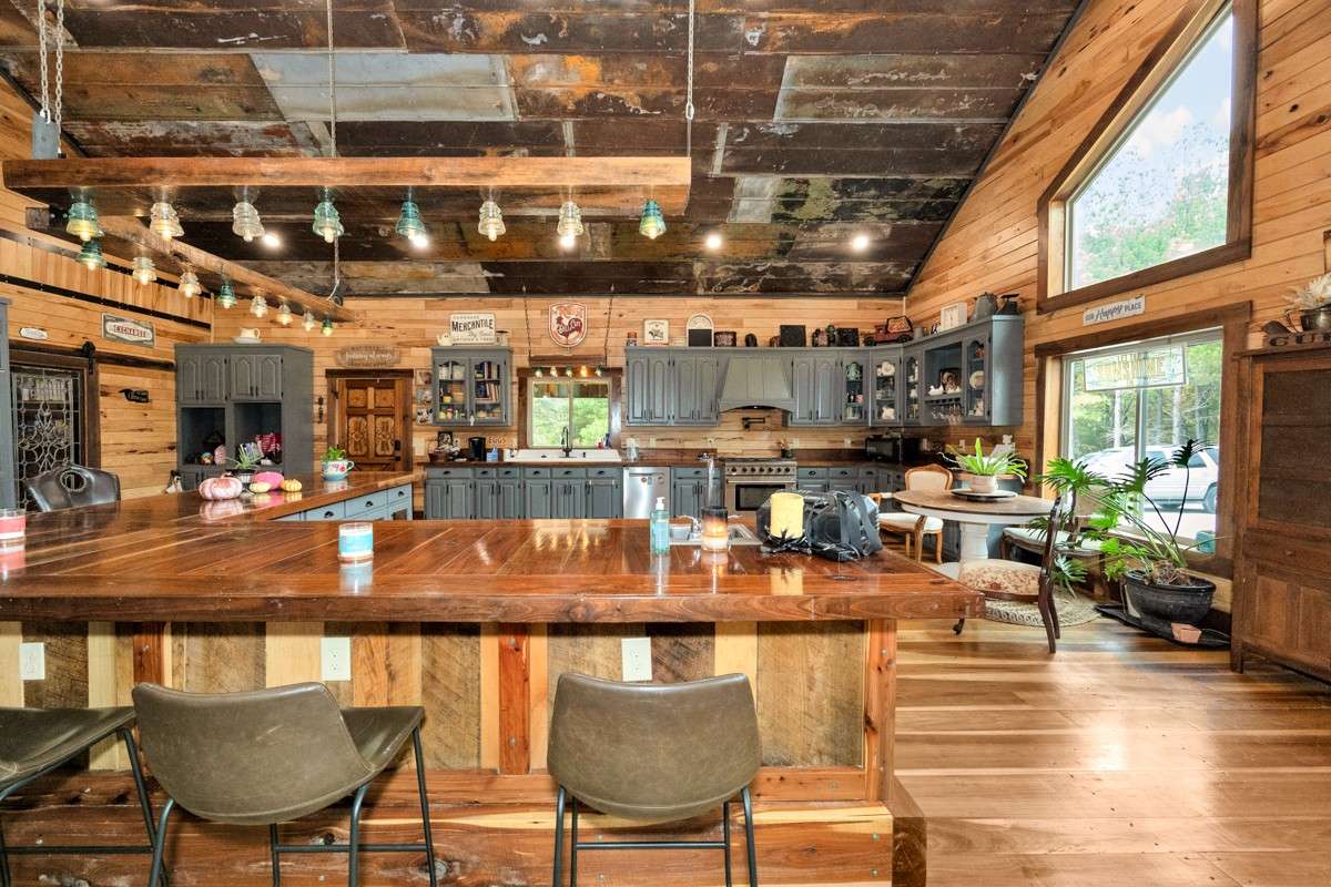 Kitchen- poplar flooring, hickory walls, large windows, walnut countertop and trim, vaulted metal roof, large windows, matching stainless appliances, large side by side refrigerator