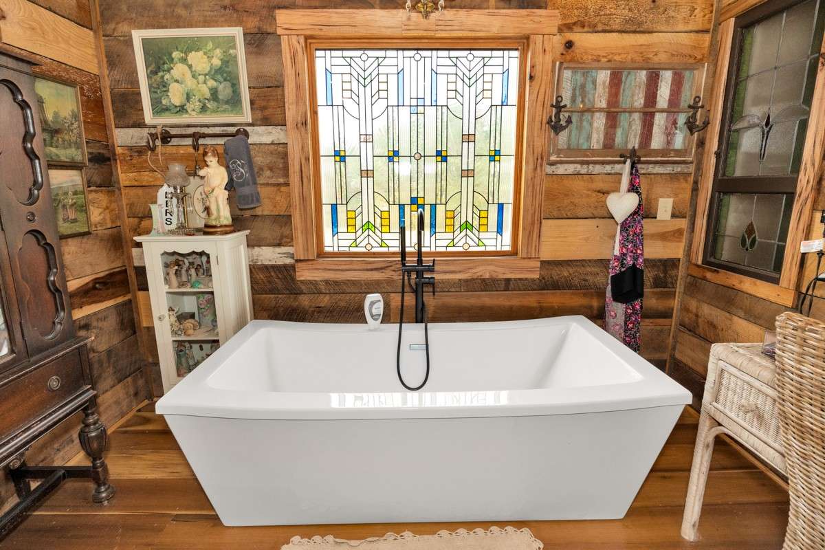Master Bath- main level- poplar flooring, hickory walls, double vanities, soaking tub, custom window, custom tile shower with two shower heads, recessed lighting