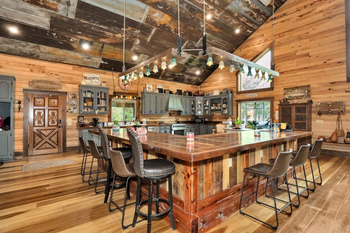 Kitchen- poplar flooring, hickory walls, large windows, walnut countertop and trim, vaulted metal roof, large windows, matching stainless appliances, large side by side refrigerator