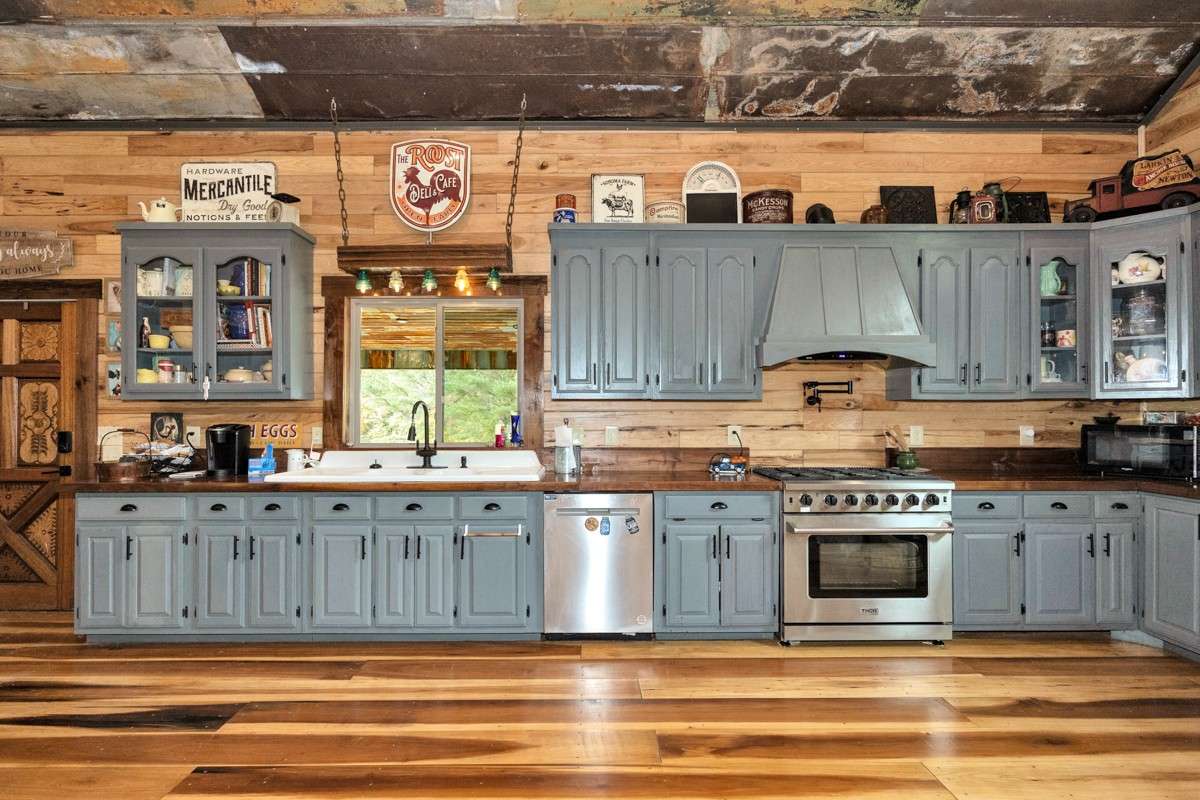 Kitchen- poplar flooring, hickory walls, large windows, walnut countertop and trim, vaulted metal roof, large windows, matching stainless appliances, large side by side refrigerator