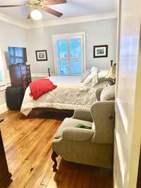 Guest bedroom on main level features a walk-in closet & en-suite bathroom.