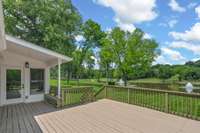 Gorgeous views of the lake and sprawling property from the rear porch—offering a peaceful setting to relax, unwind, and take in the natural beauty that surrounds you.