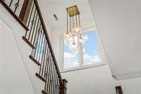 Stairs lead to the upper level, featuring a spacious bonus room above the garage, entertainment rooms, and two additional bedrooms with full ensuite bathrooms—ideal for family or guests.