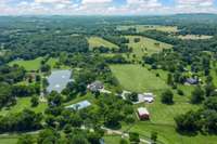 Aerial view from the rear of the property, looking toward prestigious Old Hillsboro Road. Equestrian estate featuring multiple paddocks and a barn with three spacious stalls—designed for both comfort and functionality.