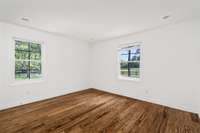 Guest bedroom located at the front of the home, filled with natural light and offering charming views of the equestrian paddocks.