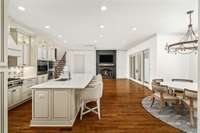 Open-concept kitchen with breakfast nook flows into an informal living room with a cozy fireplace. Sliding doors lead to the outdoor living space, ideal for entertaining and enjoying tranquil views of the expansive property. and 3-acre lake.