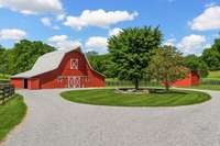 1930s horse stable transformed into speakeasy barn with full bath, utilities, concrete slab, industrial fans, and upper swing doors. 3 horse stalls along the side.