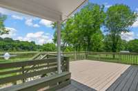 Gorgeous views of the lake and sprawling property from the rear porch—offering a peaceful setting to relax, unwind, and take in the natural beauty that surrounds you.