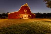 Renovated 1930s speakeasy barn blends vintage charm with modern utility, featuring three working horse stalls adjacent to all paddocks—perfect for equestrian living with a touch of historic character.