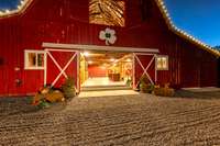 Rolling barn doors open to reveal a grand entertaining space—perfect for gatherings, events, or relaxing in a unique setting that blends rustic charm with open-concept design. Currently unfurnished.